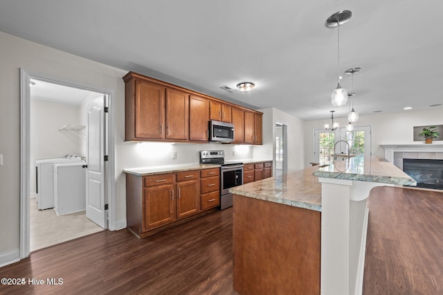 106 Waterside Dr, Bath, NC 27808 - kitchen with appliances with stainless steel finishes, independent washer and dryer, dark wood-style floors, and brown cabinetry