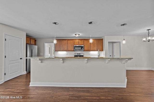 106 Waterside Dr, Bath, NC 27808 - kitchen featuring appliances with stainless steel finishes, brown cabinets, and a breakfast bar