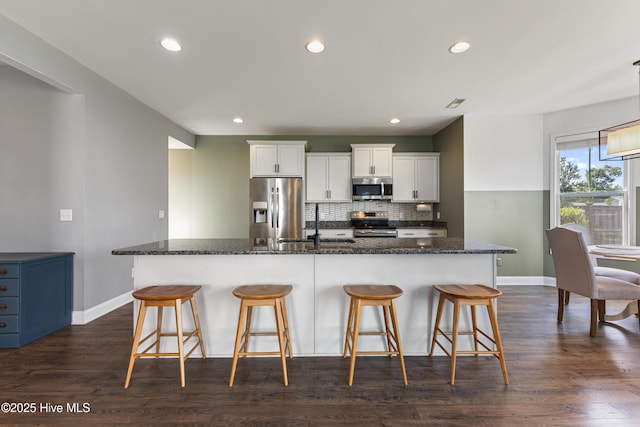 737 Heartwood Dr, Leland, NC 28479 - kitchen featuring stainless steel appliances, baseboards, a kitchen breakfast bar, backsplash, and recessed lighting