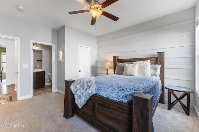 737 Heartwood Dr, Leland, NC 28479 - bedroom with light carpet, baseboards, ensuite bath, and a ceiling fan