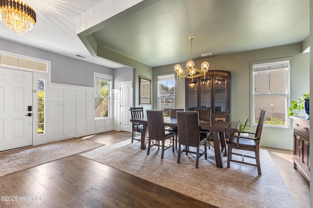 737 Heartwood Dr, Leland, NC 28479 - dining space with a chandelier, wood finished floors, a decorative wall, and wainscoting
