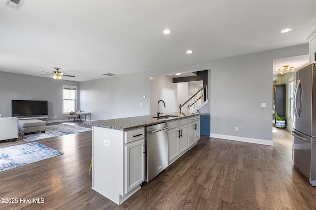 737 Heartwood Dr, Leland, NC 28479 - kitchen featuring stainless steel appliances, a ceiling fan, white cabinetry, dark stone countertops, and dark wood finished floors