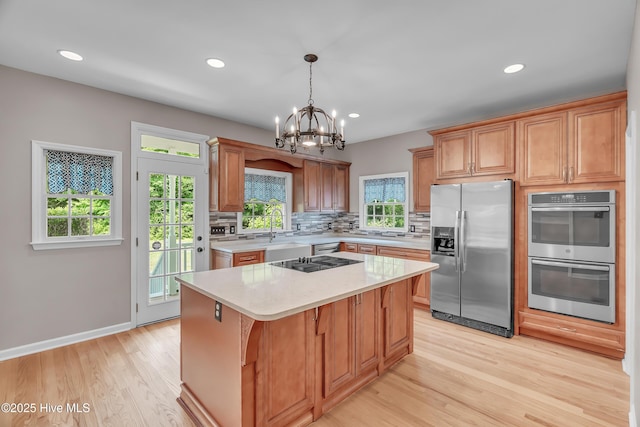 142 Magens Way, Cedar Point, NC 28584 - kitchen featuring appliances with stainless steel finishes, light countertops, tasteful backsplash, a chandelier, and light wood finished floors