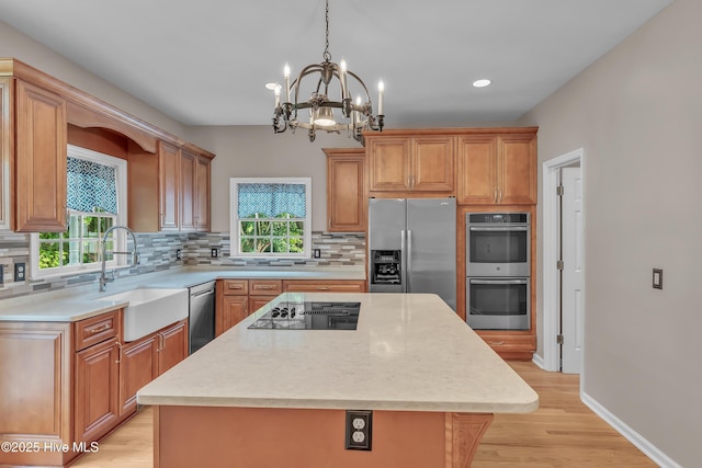 142 Magens Way, Cedar Point, NC 28584 - kitchen featuring appliances with stainless steel finishes, a sink, a chandelier, light countertops, and tasteful backsplash