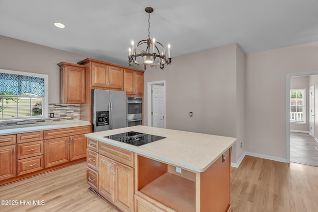 142 Magens Way, Cedar Point, NC 28584 - kitchen with stainless steel appliances, light countertops, a chandelier, tasteful backsplash, and a kitchen island