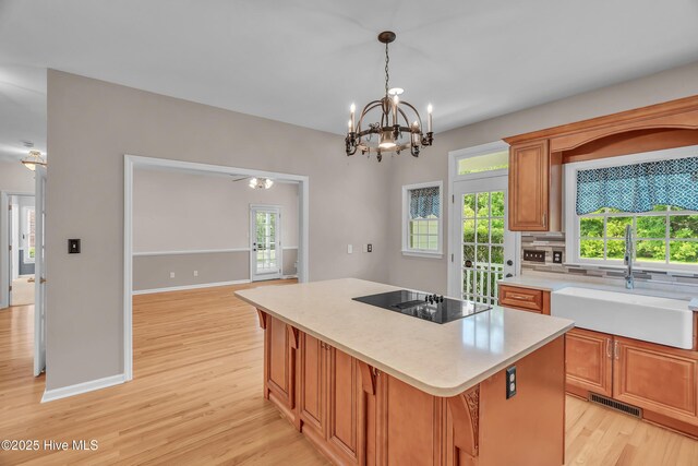 142 Magens Way, Cedar Point, NC 28584 - kitchen featuring black electric stovetop, a sink, light wood-style flooring, light countertops, and a kitchen island