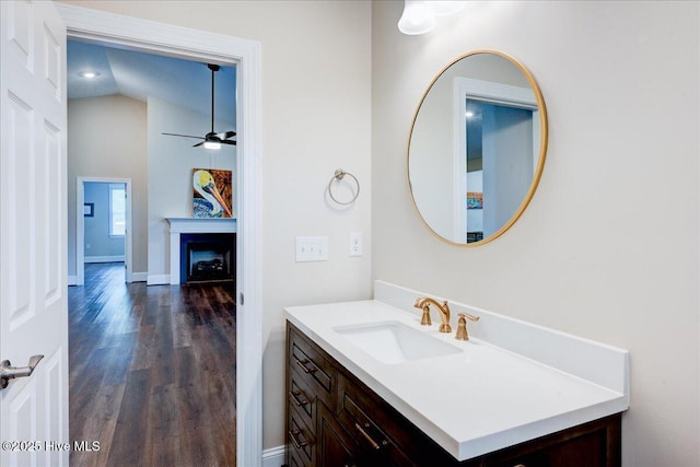 409 Kinnakeet Ln, New Bern, NC 28562 - bathroom with wood finished floors, vanity, a ceiling fan, a fireplace, and vaulted ceiling