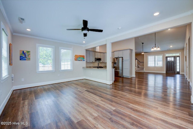 409 Kinnakeet Ln, New Bern, NC 28562 - unfurnished living room featuring stairway, a sink, wood finished floors, ornamental molding, and baseboards