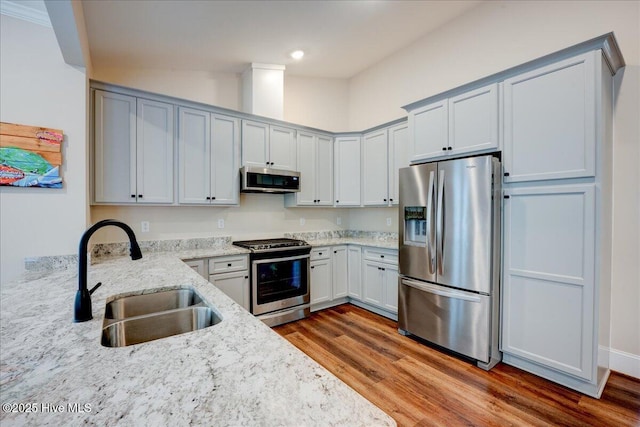409 Kinnakeet Ln, New Bern, NC 28562 - kitchen featuring appliances with stainless steel finishes, a sink, light stone countertops, wood finished floors, and recessed lighting