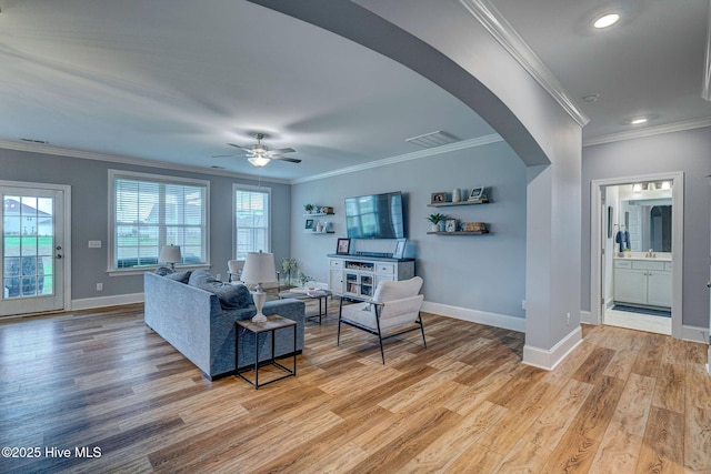 1279 Pandion Dr, Wilmington, NC 28411 - living area featuring arched walkways, baseboards, light wood-style floors, crown molding, and a ceiling fan