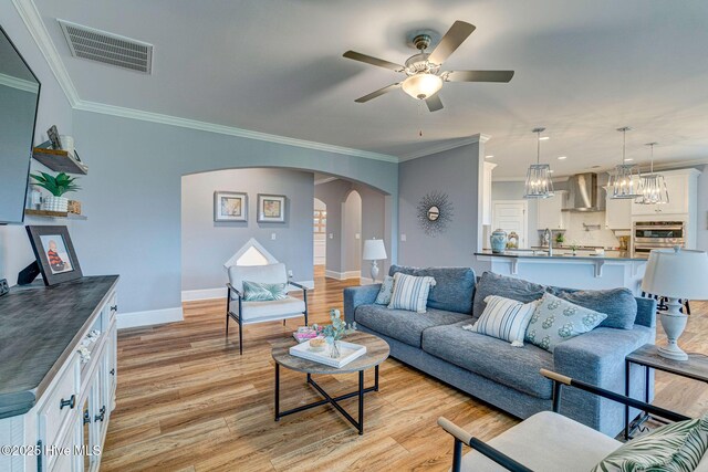 1279 Pandion Dr, Wilmington, NC 28411 - living area with light wood finished floors, arched walkways, ornamental molding, baseboards, and ceiling fan