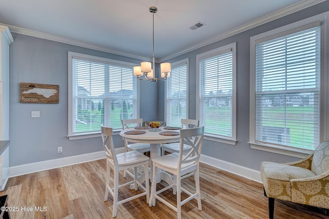 1279 Pandion Dr, Wilmington, NC 28411 - dining area featuring a chandelier, baseboards, light wood finished floors, and crown molding