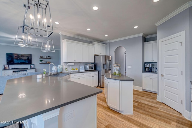 1279 Pandion Dr, Wilmington, NC 28411 - kitchen featuring a sink, stainless steel fridge with ice dispenser, arched walkways, dark countertops, and ornamental molding