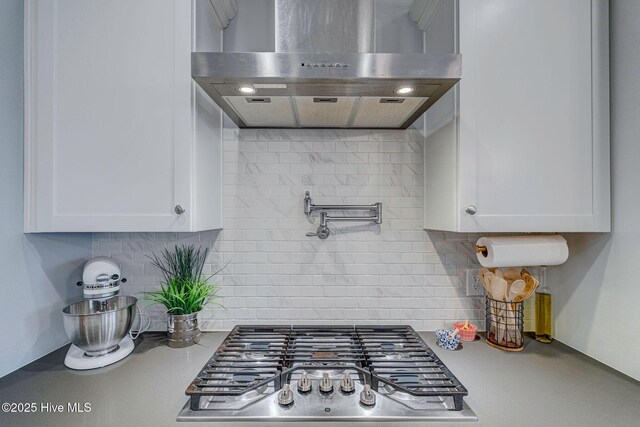 1279 Pandion Dr, Wilmington, NC 28411 - kitchen with exhaust hood, stainless steel gas stovetop, decorative backsplash, and white cabinetry