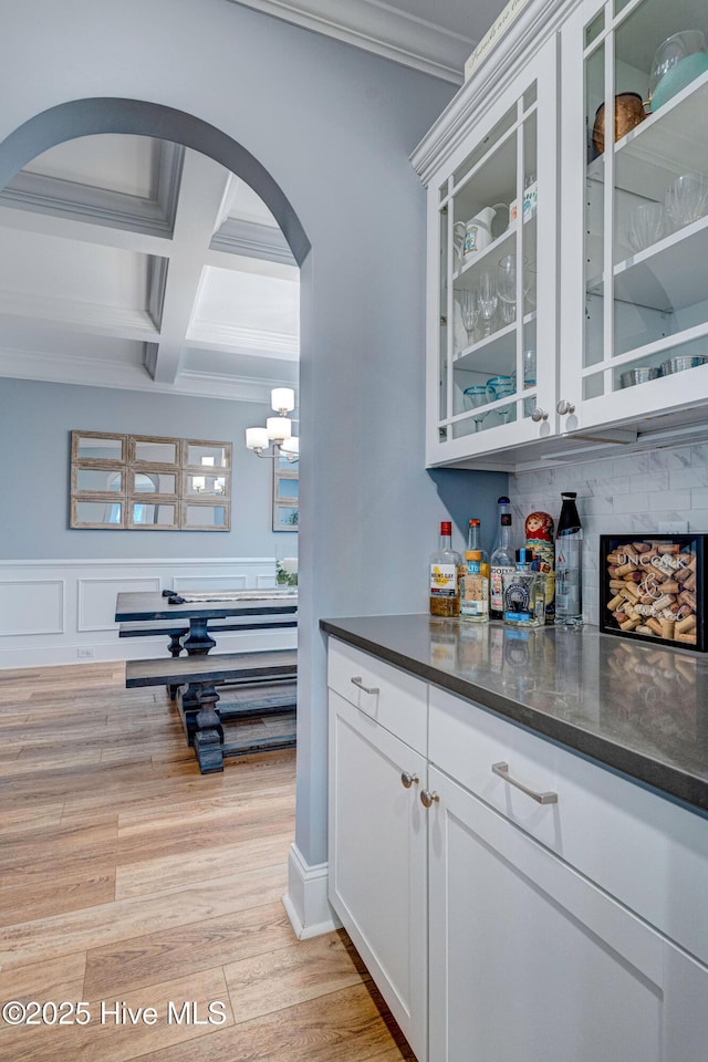 1279 Pandion Dr, Wilmington, NC 28411 - indoor dry bar with arched walkways, coffered ceiling, ornamental molding, beamed ceiling, and light wood-style floors