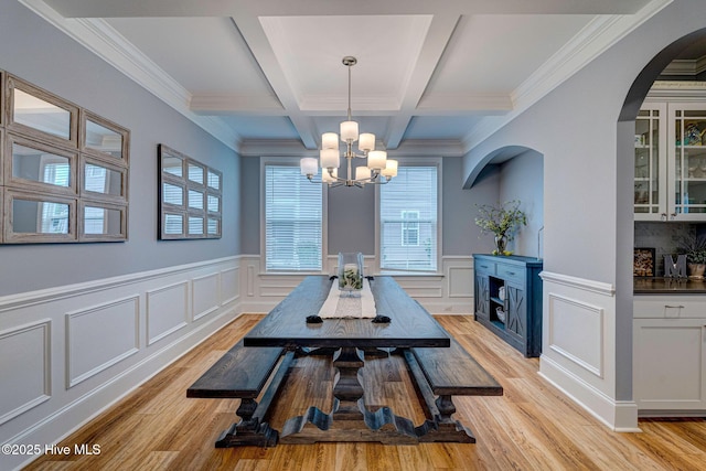 1279 Pandion Dr, Wilmington, NC 28411 - dining space with arched walkways, a chandelier, beam ceiling, light wood-style flooring, and a decorative wall