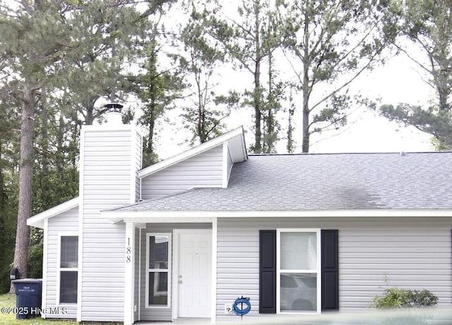 188 Village Cir, Jacksonville, NC 28546 - mid-century home featuring a shingled roof and a chimney
