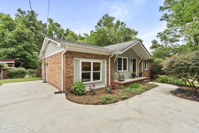 109 Dilworth Rd, Wilmington, NC 28411 - view of side of property featuring brick siding, covered porch, concrete driveway, and a shingled roof
