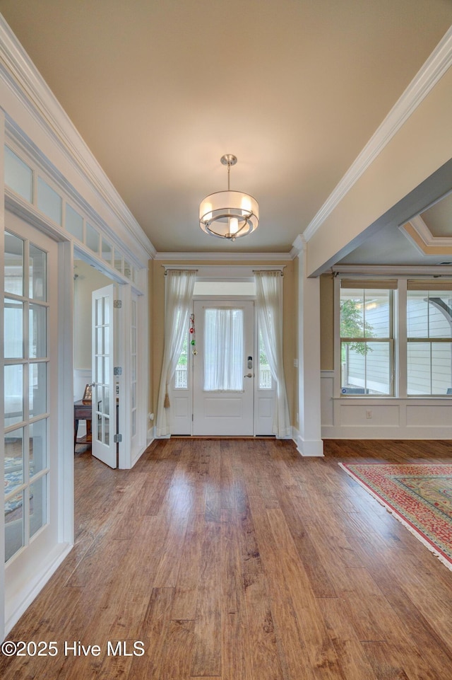 7406 Songbird Ct, Wilmington, NC 28411 - entryway with ornamental molding, wood finished floors, french doors, a chandelier, and a decorative wall