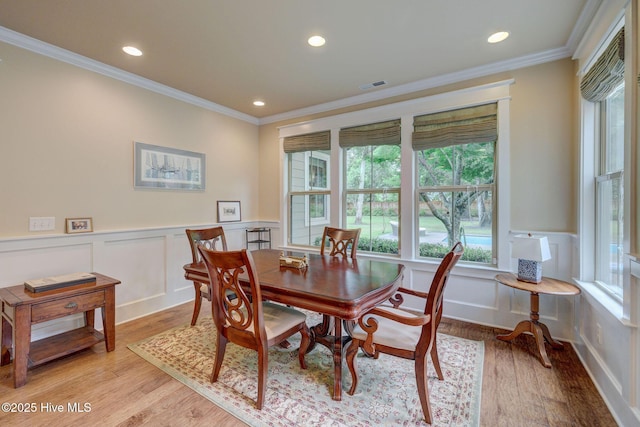 7406 Songbird Ct, Wilmington, NC 28411 - dining area with crown molding, a decorative wall, light wood-type flooring, recessed lighting, and wainscoting