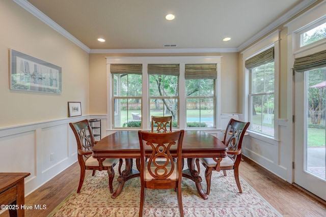7406 Songbird Ct, Wilmington, NC 28411 - dining space featuring crown molding, light wood-type flooring, a decorative wall, wainscoting, and recessed lighting