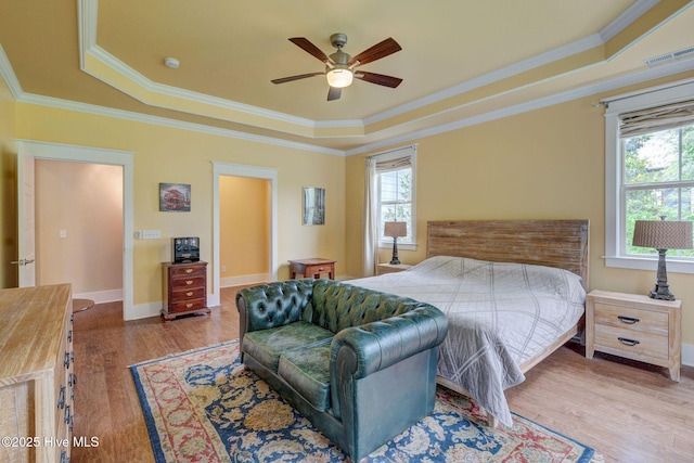7406 Songbird Ct, Wilmington, NC 28411 - bedroom featuring a tray ceiling, multiple windows, ornamental molding, wood finished floors, and baseboards