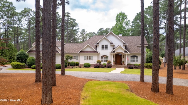 370 Lake Dornoch Dr, Pinehurst, NC 28374 - view of front of property featuring roof with shingles, a front lawn, gravel driveway, and a chimney