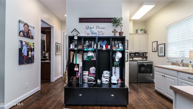 370 Lake Dornoch Dr, Pinehurst, NC 28374 - kitchen featuring washer and dryer, a sink, dark wood-style floors, and white cabinetry