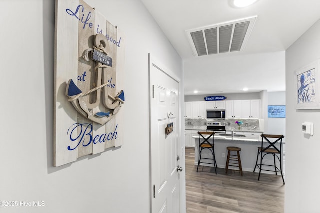 940 Pine Needles Rd, Southport, NC 28461 - hall with a sink, wood finished floors, and recessed lighting