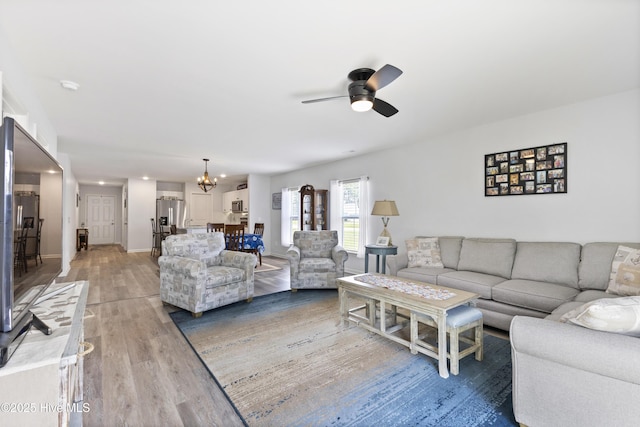 940 Pine Needles Rd, Southport, NC 28461 - living area with a ceiling fan, light wood finished floors, a chandelier, and baseboards