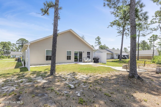 940 Pine Needles Rd, Southport, NC 28461 - rear view of house with a patio area, central AC, and a yard