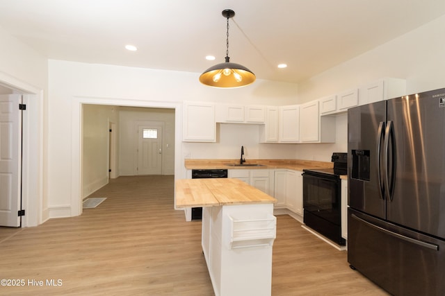 502 Sterlingworth St, Windsor, NC 27983 - kitchen featuring stainless steel fridge, electric range, wooden counters, white cabinetry, and light wood-type flooring