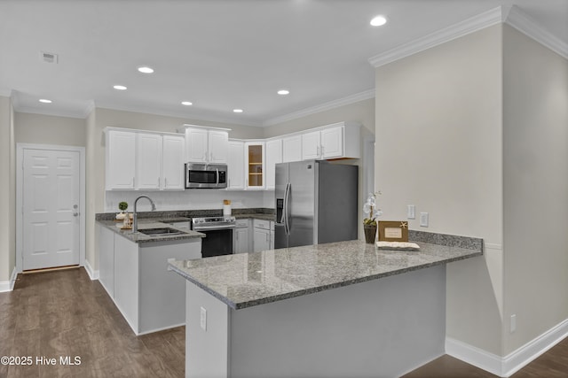 1113 Foxbow Cv, Leland, NC 28451 - kitchen with appliances with stainless steel finishes, a peninsula, a sink, dark stone counters, and white cabinets