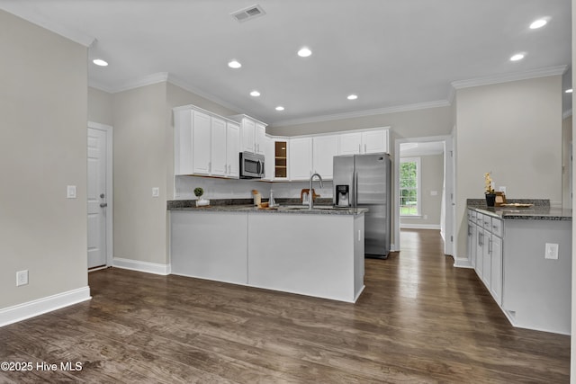 1113 Foxbow Cv, Leland, NC 28451 - kitchen with appliances with stainless steel finishes, a peninsula, baseboards, crown molding, and white cabinets