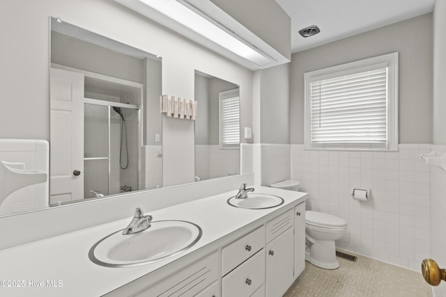 405 E Westbrook St, Wallace, NC 28466 - full bathroom featuring wainscoting, double vanity, toilet, a tile shower, and tile walls