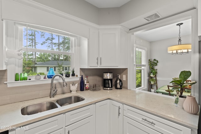 405 E Westbrook St, Wallace, NC 28466 - kitchen featuring a sink, decorative backsplash, white cabinets, and decorative light fixtures
