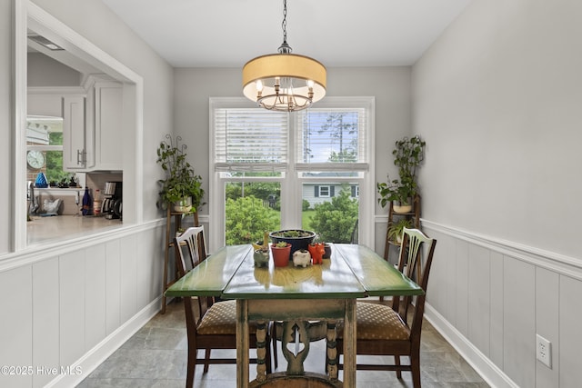 405 E Westbrook St, Wallace, NC 28466 - dining space featuring wainscoting, light stone finish floors, a chandelier, and a decorative wall