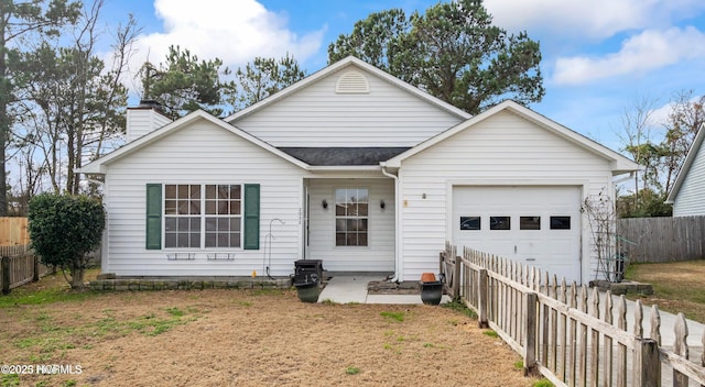 2032 W W Windgate Ct, Jacksonville, NC 28546 - view of front of property featuring an attached garage, driveway, a fenced backyard, and a chimney