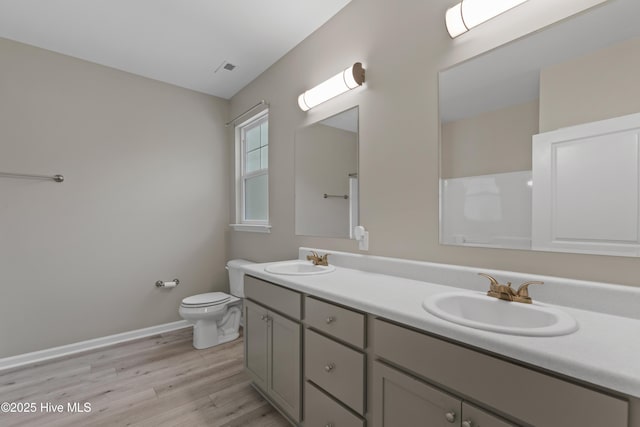 218 Spring Dr, Jacksonville, NC 28540 - full bath with double vanity, wood finished floors, toilet, and baseboards