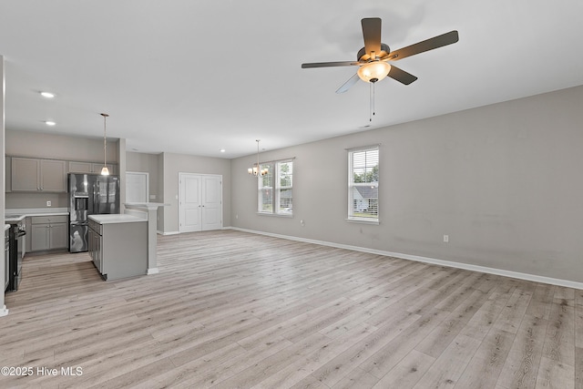 218 Spring Dr, Jacksonville, NC 28540 - unfurnished living room featuring light wood-type flooring, ceiling fan, baseboards, a chandelier, and recessed lighting