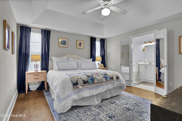 2122 Airlie Brook Dr, Wilmington, NC 28403 - bedroom featuring a tray ceiling, light wood-style flooring, and multiple windows