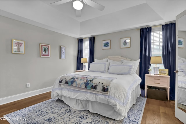 2122 Airlie Brook Dr, Wilmington, NC 28403 - bedroom with wood finished floors, a tray ceiling, multiple windows, and a ceiling fan