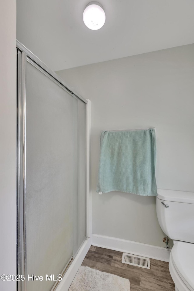 601 Mary Ann Dr, Hampstead, NC 28443 - full bathroom featuring toilet, a shower stall, baseboards, and wood finished floors