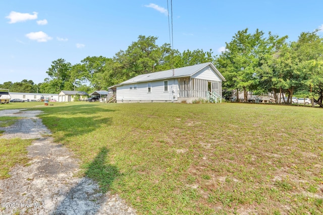 601 Mary Ann Dr, Hampstead, NC 28443 - view of front of home with a front yard, metal roof, and entry steps