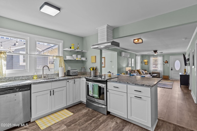 208 Hamlet Ave, Carolina Beach, NC 28428 - kitchen featuring stainless steel appliances, a sink, a peninsula, a wall mounted AC, and dark wood-style floors