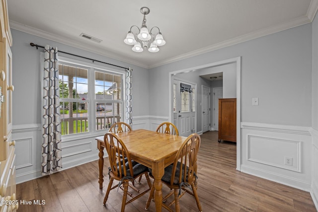 2902 Brems Battery, New Bern, NC 28562 - dining room featuring a chandelier, wood finished floors, ornamental molding, a wainscoted wall, and a decorative wall