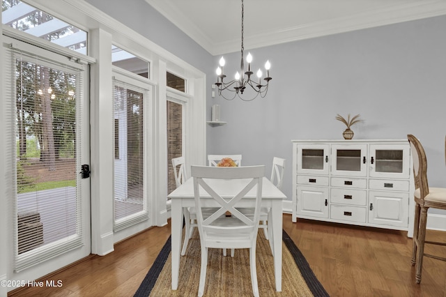 3807 Ridge Crest Dr, Southport, NC 28461 - dining area featuring dark wood-style flooring, a chandelier, and crown molding