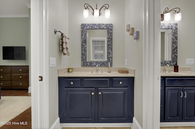 3807 Ridge Crest Dr, Southport, NC 28461 - full bath featuring two vanities, wood finished floors, baseboards, and ornamental molding