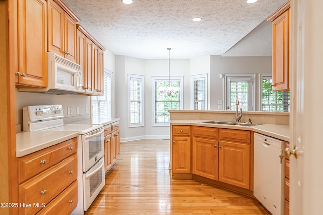 114 Baker Cir W, End, NC 27376 - kitchen featuring white appliances, a sink, a textured ceiling, light wood-style flooring, and light countertops