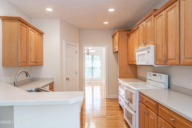 114 Baker Cir W, End, NC 27376 - kitchen with white appliances, a sink, recessed lighting, light wood finished floors, and light countertops